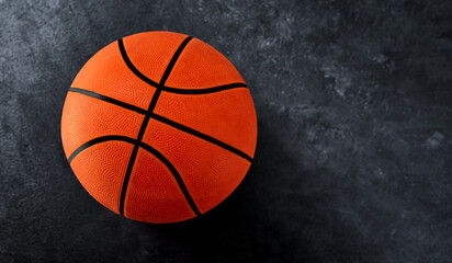 The ball is in your court. High angle shot of a single basket ball placed on top of a dark background inside of a studio.
