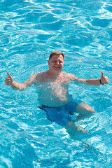 Happy man swimming pool with his thumbs up.