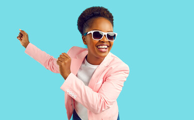 Cheerful and joyful carefree dancing laughing african american happy woman waving her hands in pink...