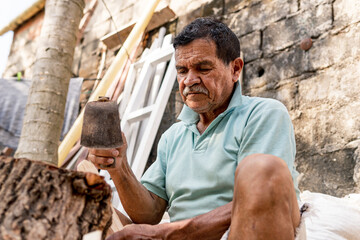 latino old man chopping wood medium shot