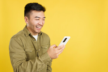 Happy chinese man smiling while using the mobile