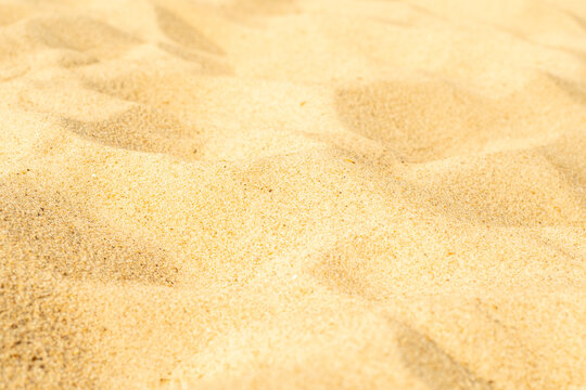 Close-up of yellow sand on the beach. Small grains of sand on a clean beach. Toned photo with low depth of field.