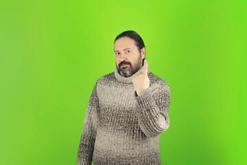 Obraz premium An adult man in a warm sweater points up with a smile. Promotion mockup template with blank space on the theme of health and wellness.