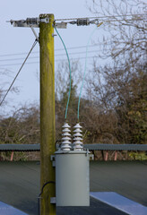 electrical transformer and cables on wooden pole