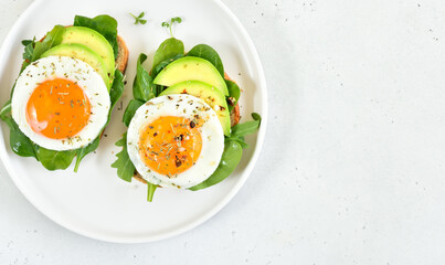 Bread with fried eggs, avocado and greens