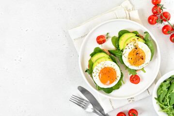Bread with fried eggs, avocado and greens