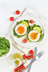 Bread with fried eggs, avocado and greens