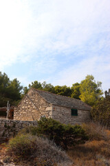 Fototapeta na wymiar Traditional stone house and wild beach on Proizd, small island near Vela Luka, Croatia.