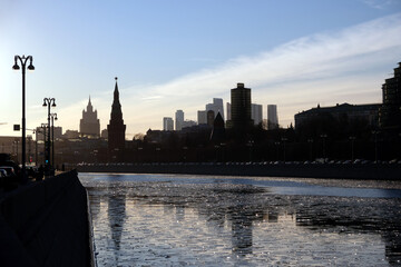 Moscow river, embankment and silhouettes of buildings and Kremlin towers under clear cloudless sky