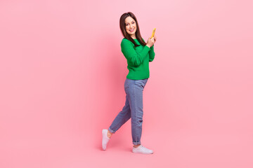 Fototapeta na wymiar Full size profile photo of cheerful lovely girl hold use smart phone empty space ad isolated on pink color background