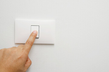 Turn off the light, close up female hand is closing the power switch. Save energy, reduce global warming..