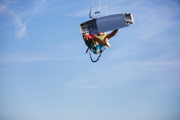Professional kiter does the difficult trick. A male kiter rides against a beautiful background of waves and performs all sorts of maneuvers.