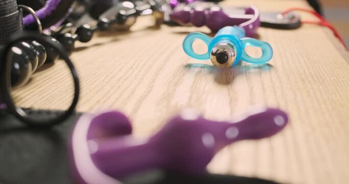 Small blue sex vibrator spins around the table. Side view, close-up. Concept of successful sex and sexual satisfaction.