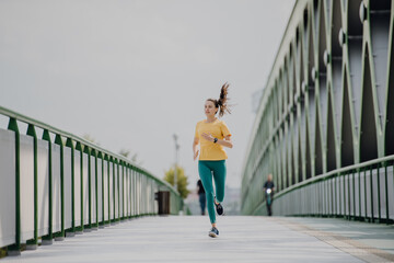 Young woman jogging at city bridge, healthy lifestyle and sport concept.