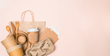 Banner with eco-friendly tableware. Kraft paper food utensils, paper containers and cups and wooden...