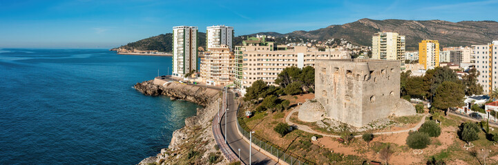 Coastal Road Panoramic View of Torre del Rey Tower at Oropesa del Mar under a Blue Sky: A Scenic Drive through History