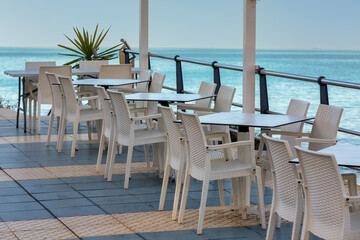 Seaside Dining: Outdoor Restaurant with Multiple Tables and Chairs