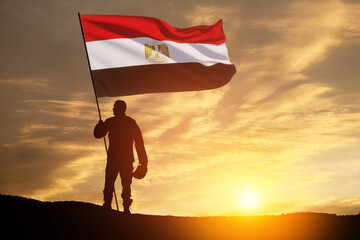 Silhouette Of A Solider with Egypt Flag Against the Sunrise in desert . Concept - armed forces of...