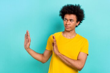 Photo of upset serious guy afro hairstyle wear yellow t-shirt look empty space rejecting offer isolated on turquoise color background - obrazy, fototapety, plakaty