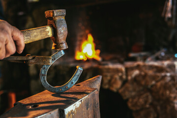Dark smithy with blacksmith tools, horseshoe