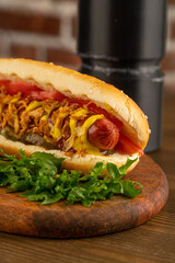 hot dog on a dark wooden background. fried sausage in sauce