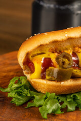 hot dog on a dark wooden background. fried sausage in sauce