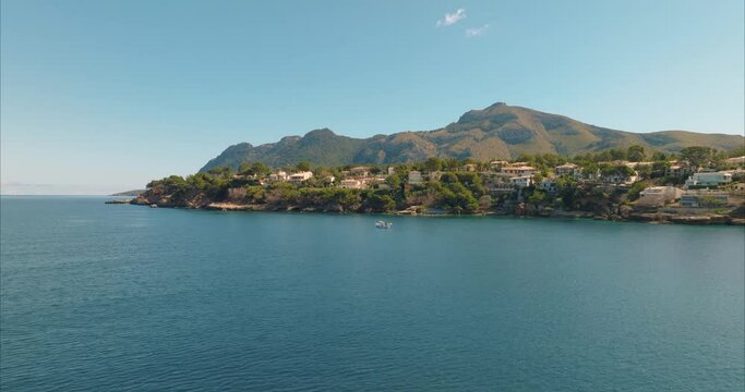 Barco con pescador pesacando con casas de fondo, mediterraneo (Dji Mavic 3 cine)