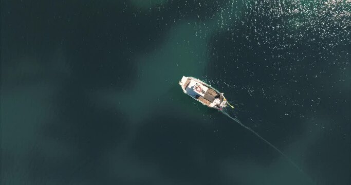 Barco con pescador pescando con casas de fondo, mediterr&aacute;neo (Dji Mavic 3 cine)