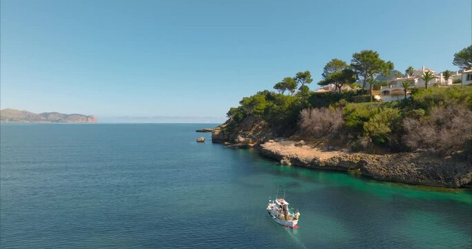 Barco con pescador pescando con casas de fondo, mediterr&aacute;neo (Dji Mavic 3 cine)