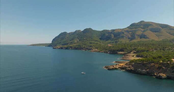 Barco con pescador pescando con casas de fondo, mediterr&aacute;neo (Dji Mavic 3 cine)