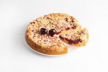 Cherry pie with a slice on a light background.