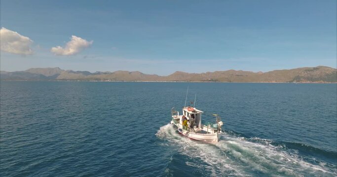 Barco con pescador pescando con casas de fondo, mediterr&aacute;neo (Dji Mavic 3 cine)