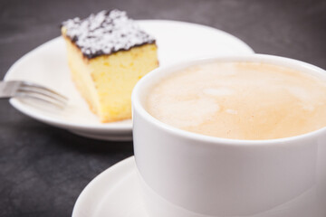 Cup of coffee with milk and fresh baked cheesecake. Delicious dessert