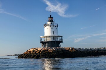 Lighthouse off the coast of Maine on rocks surrounded by seascape