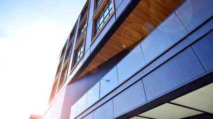 A modern corporate building in the city.  The blue sky is reflected in the buildings large glass windows. Glass facade.