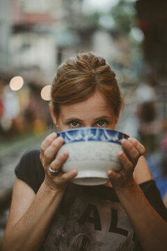 Close-up of a woman slurping a bowl of noodles, Vietnam