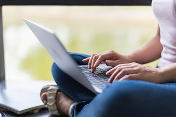Asian female student Studying for exams in the area of the university. Communicate via mobile phone or laptop connected to the Internet. with many sources of knowledge