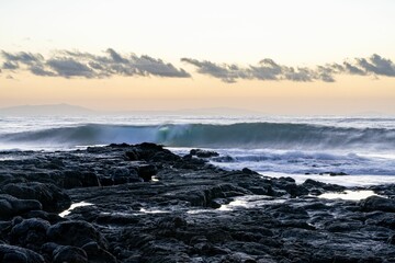Beautiful seascape view with white and foamy waves against a scenic sunrise in Oahu, Hawaii