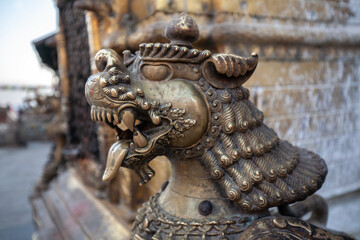 Fototapeta na wymiar Lion statue at Swayambhunath or is an ancient religious complex atop a hill, The complex consists of a stupa, a variety of shrine and temple