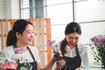 Two florist are arranging flowers to deliver to customers in the flower shop.