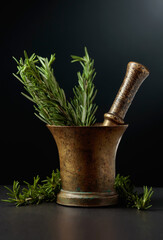 Old brass mortar with fresh rosemary branches.