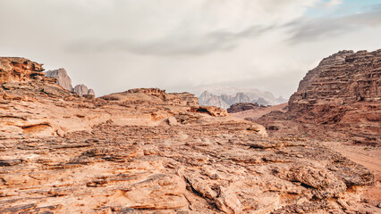 Red orange Mars like landscape in Jordan Wadi Rum desert, mountains background, overcast morning. This location was used as set for many science fiction movies