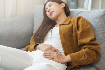 Flatulence asian young woman hand in stomach ache, suffer from food poisoning, abdominal pain and...