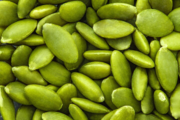 Pumpkin seeds close-up, green, in bulk, full depth of field