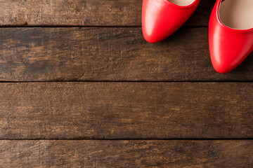 Red high heels on wooden background with copyspace. Top view