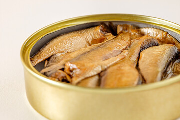 Sprats, smoked canned fish in oil, in open tin can, close-up selective focus