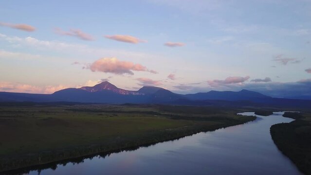 Drone shot of green meadows Jungle by reflecting river in Canaima, Venezuela at sunset