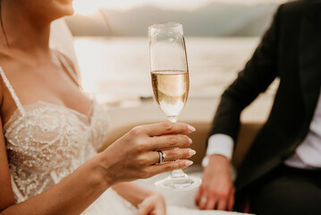 bride and groom newlyweds drinking champagne wine on boat on wedding day sunset romantic boho 