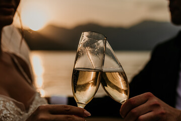 bride and groom newlyweds drinking champagne wine on boat on wedding day sunset romantic boho 
