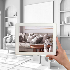 Augmented reality concept. Hand holding tablet with AR application used to simulate furniture products in custom architecture design, total white background, farmhouse living room